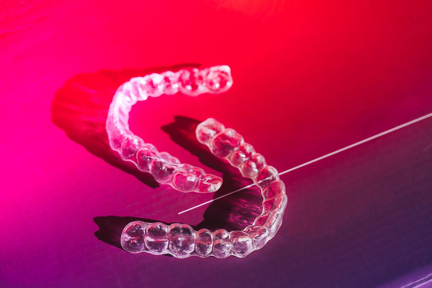 Zwei Aligner auf einem Lila und Rotem Hintergrund