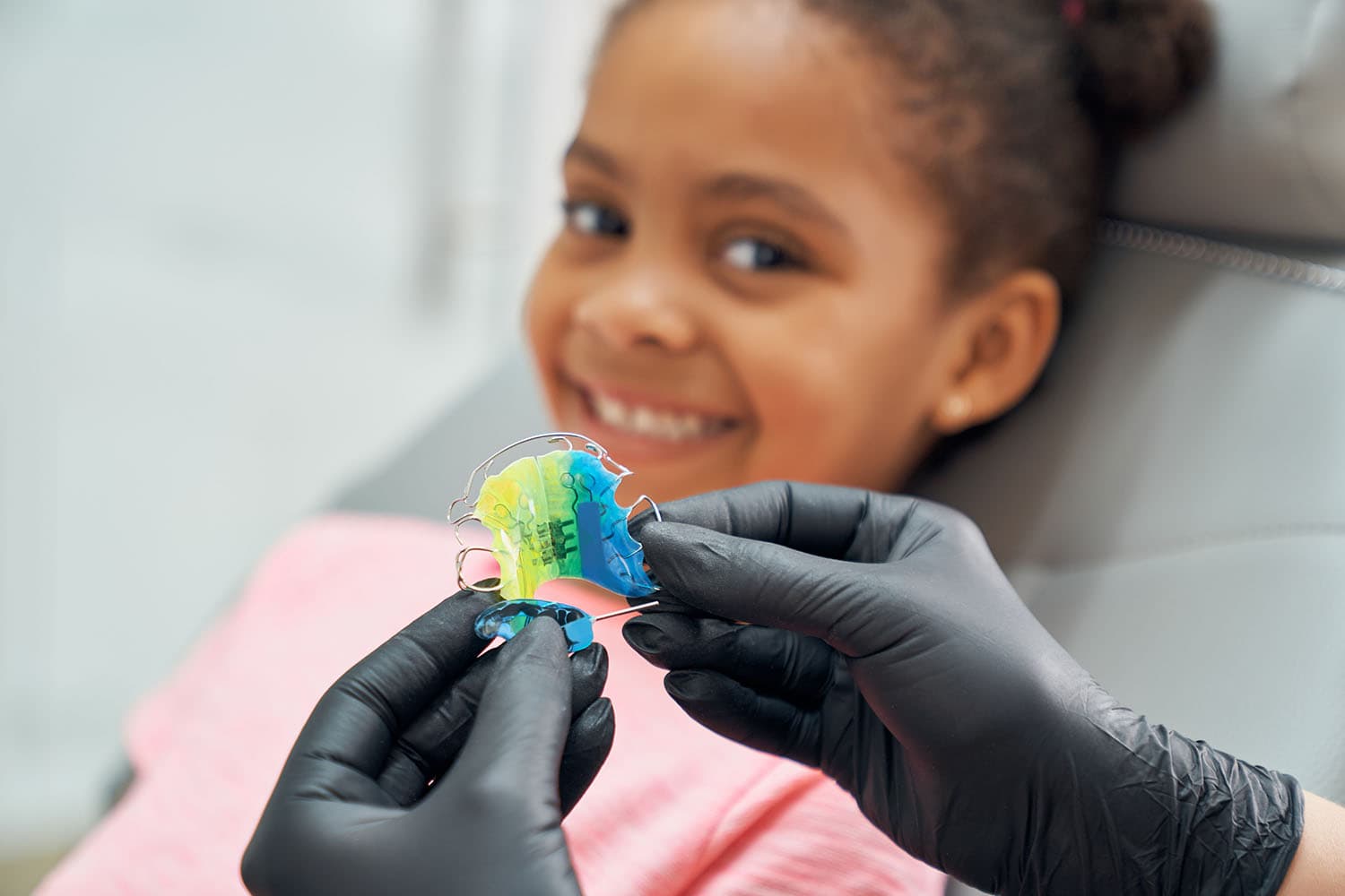 Kieferorthopäde gibt ein junges Mädchen ihre Herausnehmbare Zahnspange